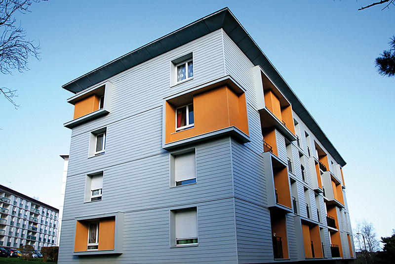 Immeuble orange et bleu dont la façade est construite avec des panneaux en ciment composite